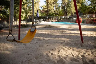 a swing seat in a park with a playground at Lupine #106 in Big Bear Lake