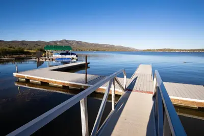 a dock on a lake with a boat in the water at Lupine #106 in Big Bear Lake