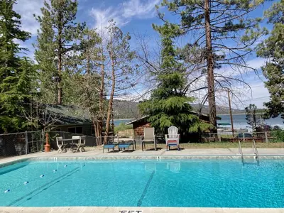a swimming pool with two chairs and a house at Sunset #101 in Big Bear Lake