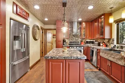 a kitchen with red cabinets and stainless steel appliances at How sweet it is #1531 in Big Bear Lake