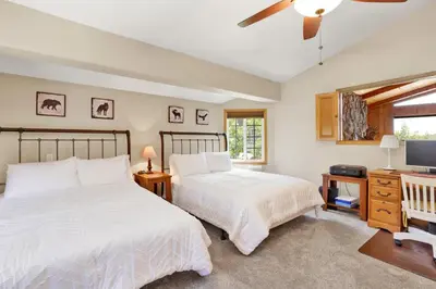 a bedroom with two beds and a desk and a television at Lakefront village castle #2312 in Big Bear Lake
