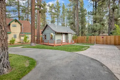 a driveway leading to a house with a fence at Beary cozy cabin #2315 in Big Bear Lake