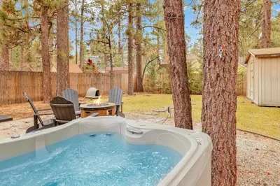 a hot tub in a yard next to a tree at Beary cozy cabin #2315 in Big Bear Lake