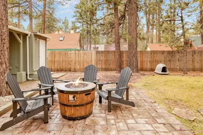 a patio with two chairs and a table with a barrel at Beary cozy cabin #2315 in Big Bear Lake