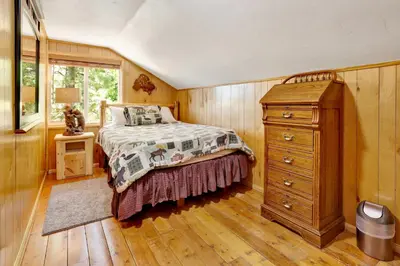 a bedroom with a bed and a dresser and a window at Circle views #1602 in Big Bear Lake