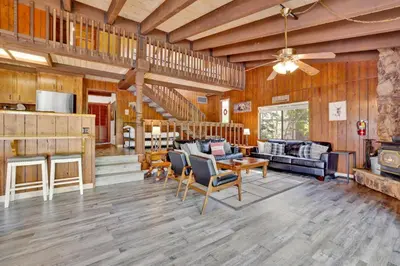 a large living room with wooden walls and wooden floors at Lakeview fishing house #121 in Big Bear Lake