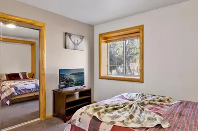 a bedroom with a bed and a mirror at Little cubs cabin #1986 in Big Bear Lake