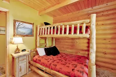 a log cabin bedroom with a bed in a room at Knotty and nice #177 in Big Bear Lake