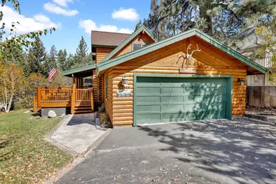 a log cabin with a green garage door at Knotty and nice #177 in Big Bear Lake