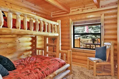 a log cabin bedroom with a bed and a window at Knotty and nice #177 in Big Bear Lake
