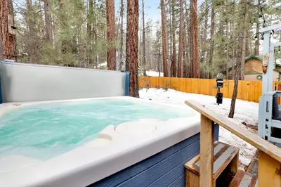 a hot tub on a deck in the woods at Blue bear chalet #2045 in Big Bear Lake