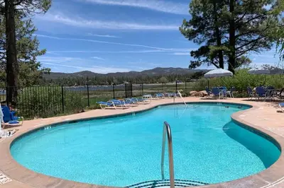 a large swimming pool with blue chairs at Cienega getaway #1952 in Big Bear Lake