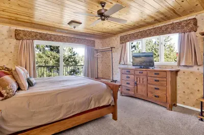 a bedroom with a bed and a dresser with a television at Cove lakefront chalet #2098 in Big Bear Lake