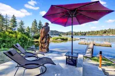 a couple of chairs and an umbrella next to a lake at Cove lakefront chalet #2098 in Big Bear Lake