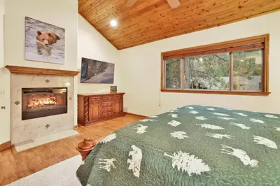 a bedroom with a fireplace and a bed at The spa at winterset #2282 in Big Bear Lake