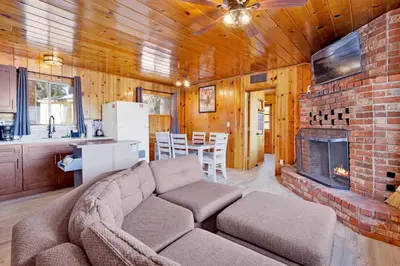 a living room with a couch and a brick fireplace at Sunrise #108 in Big Bear Lake