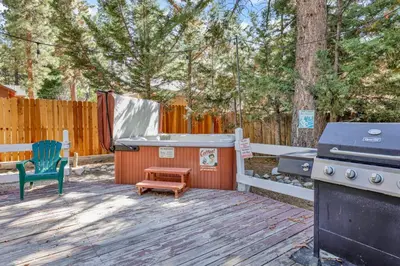 a backyard with a grill and a bench and a stool at Cozy up to summit #1651 in Big Bear Lake
