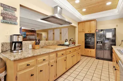 a large kitchen with wooden cabinets and stainless steel appliances at Cozy up to summit #1651 in Big Bear Lake
