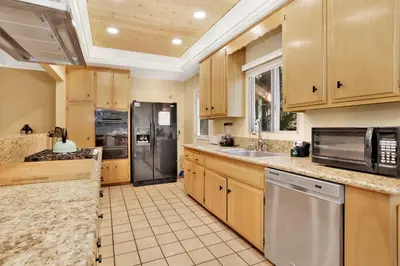 a kitchen with wooden cabinets and stainless steel appliances at Cozy up to summit #1651 in Big Bear Lake