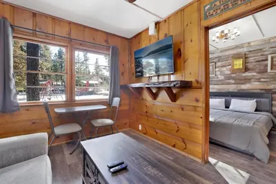 a bedroom with a bed and a table in a room at Juniper #105 in Big Bear Lake