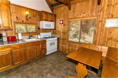 a kitchen with wooden cabinets and a wooden table at Grandpas axe # 1775 in Big Bear Lake