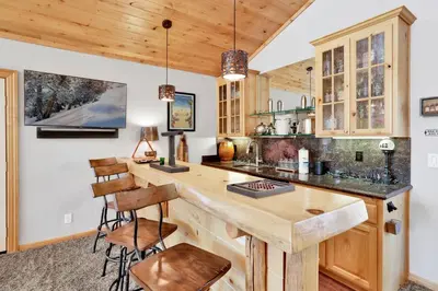 a kitchen with wooden cabinets and a counter with stools at Gold rush lodge #2352 in Big Bear Lake