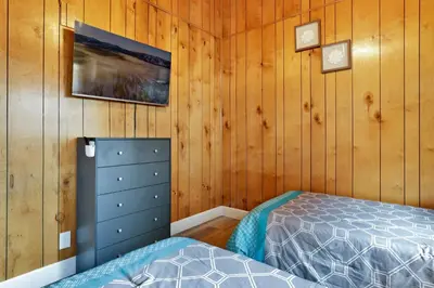 a bedroom with a bed and wooden walls at Sweet retreat combo #2334 in Big Bear Lake