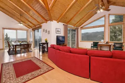 a living room with a red couch and a table at Starlight vistas #1524 in Big Bear Lake
