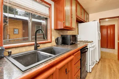 a kitchen with a sink and a white refrigerator at Swiss delight #2244 in Big Bear Lake