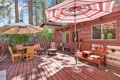 a deck with a table and chairs and an umbrella at Pine cone cottage #2191 in Big Bear Lake