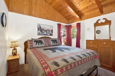 a bedroom with a bed and a wooden ceiling at Pine cone cottage #2191 in Big Bear Lake