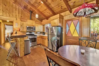 a kitchen with wooden cabinets and a table in a kitchen at Pine cone cottage #2191 in Big Bear Lake
