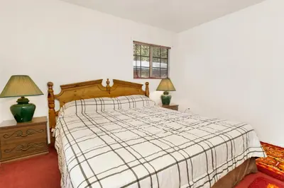 a bedroom with a bed and two lamps and a window at Cozy summit #2222 in Big Bear Lake