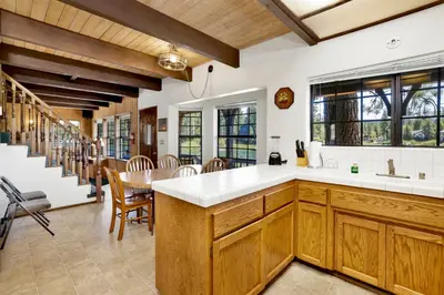 a kitchen with wooden cabinets and a table and chairs at Breezy two #113 in Big Bear Lake