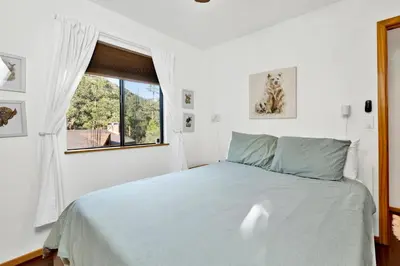 a white bedroom with a bed and a window at Chimney Peak Chalet#2048 in Big Bear City