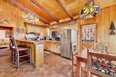 a kitchen with a stainless steel refrigerator and wooden walls at Casa catalina #667 in Big Bear Lake