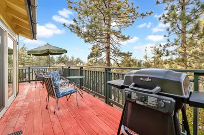 a grill on a deck with a table and chairs at A hidden asset #2379 in Big Bear Lake