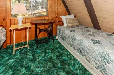 a bedroom with a bed and a table and a window at MAKIN' MEMORIES AT SUMMIT #1683 in Big Bear Lake