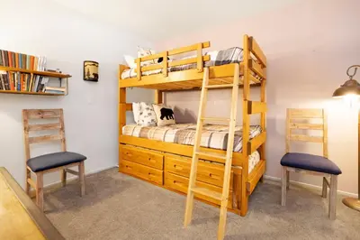 a bedroom with a bunk bed and two chairs at BROWNIE'S DEN #2205 in Big Bear Lake