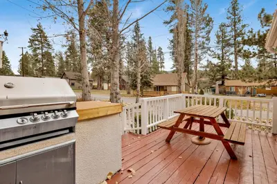 a grill and a picnic table on a wooden deck at Little bear #1079 in Big Bear Lake