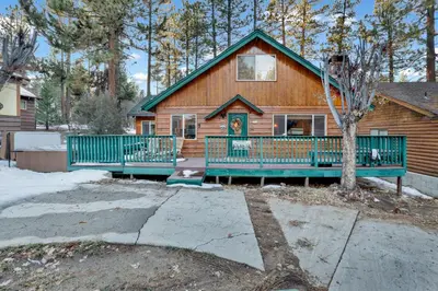 a log house with a green fence in front of it at Big bear happy place #2421 in Big Bear Lake