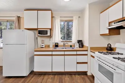 a kitchen with white cabinets and a white refrigerator at Twin pines #111 in Big Bear Lake