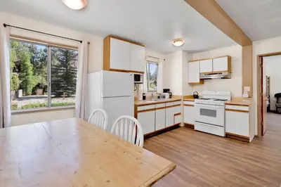 a kitchen with white appliances and a wooden table at Twin pines #111 in Big Bear Lake