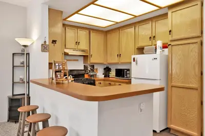 a kitchen with wooden cabinets and a white refrigerator at Restmoore #2425 in Big Bear Lake