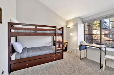 a bedroom with two bunk beds and a desk at Restmoore #2425 in Big Bear Lake