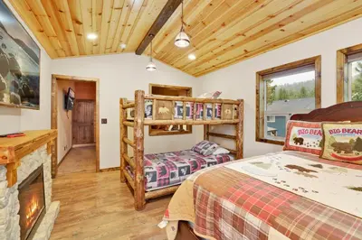 a log cabin bedroom with a bed and a fireplace at Luxury lodge #1888 in Big Bear Lake