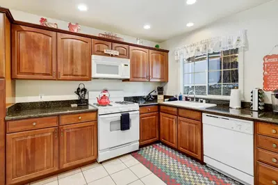 a kitchen with wooden cabinets and white appliances at Mockingbird getaway #2091 in Big Bear Lake