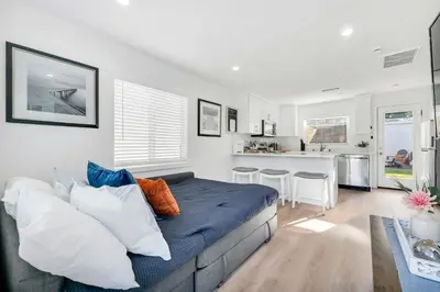 a living room with a couch and a kitchen at Cozy Cottage, Brand New, fully Private, walk to Everything in Thousand Oaks