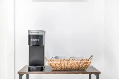 a coffee machine on a table next to a basket at Cozy Cottage, Brand New, fully Private, walk to Everything in Thousand Oaks