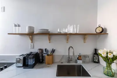 a kitchen counter with a sink and a clock on a shelf at Free Parking Pasadena Room near Convention Center & Caltech in Pasadena